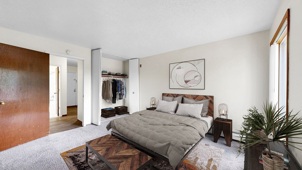 A bedroom with a large bed and a wooden floor.