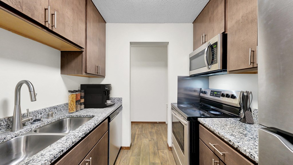 A kitchen with brown cabinets and a white door.