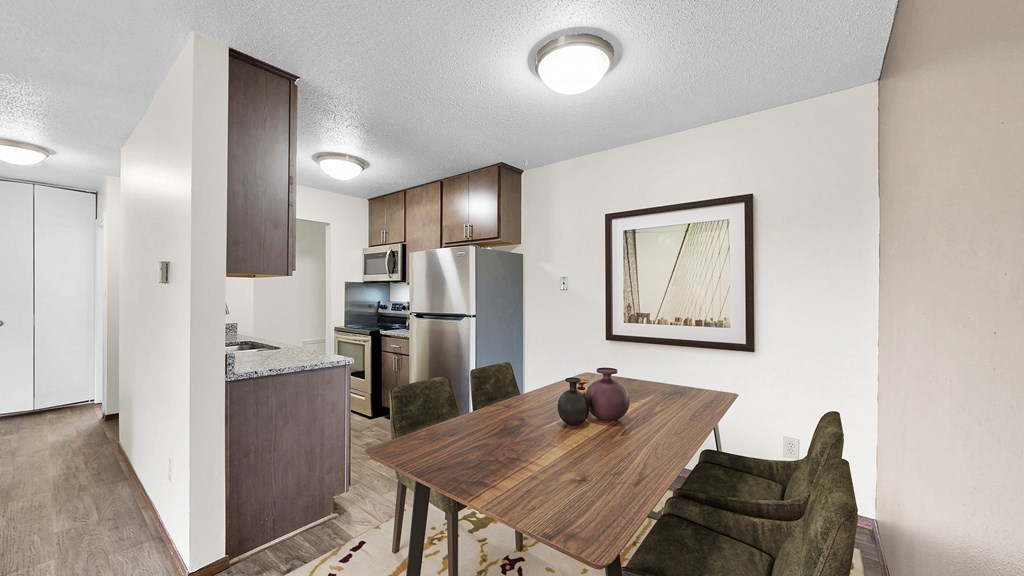 A kitchen area with a table and chairs.