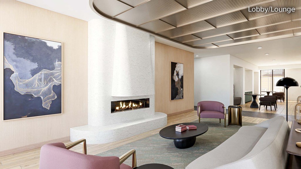 A modern lobby with a fireplace and a painting on the wall.