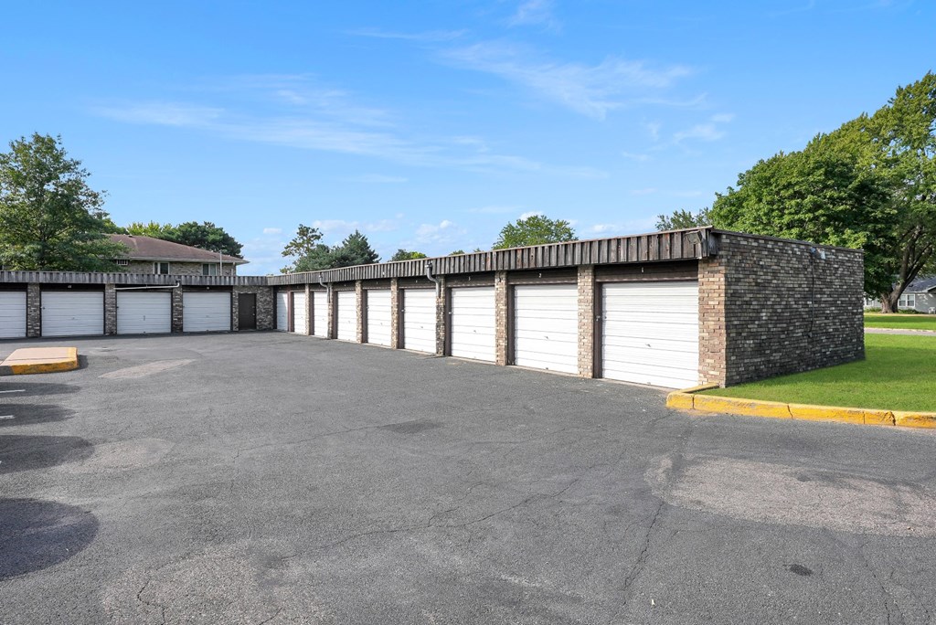 a row of white garage doors in a parking lot