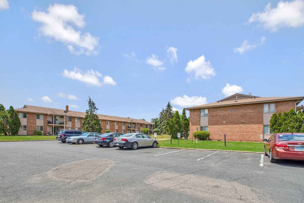 a parking lot with cars in front of an apartment building