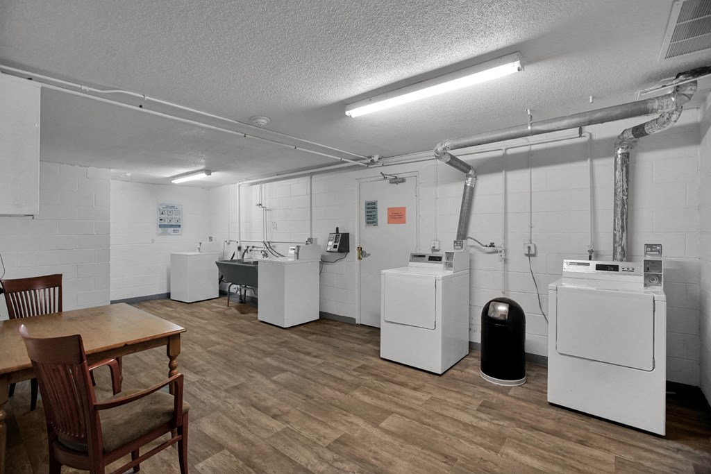 an empty room with washing machines and a table