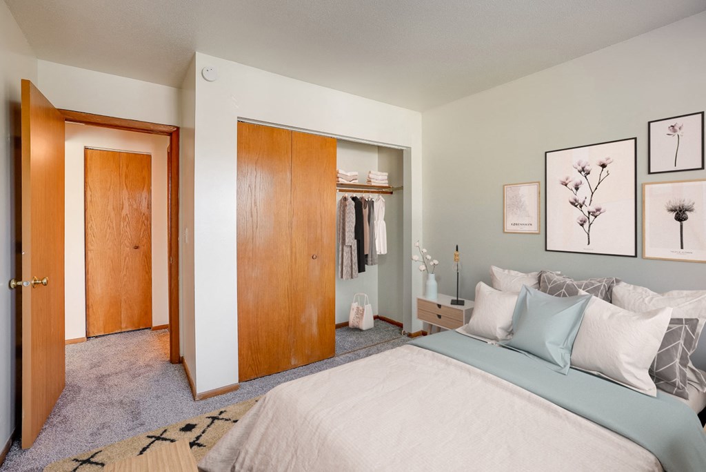 a bedroom with a bed and a closet and a door to a wardrobe