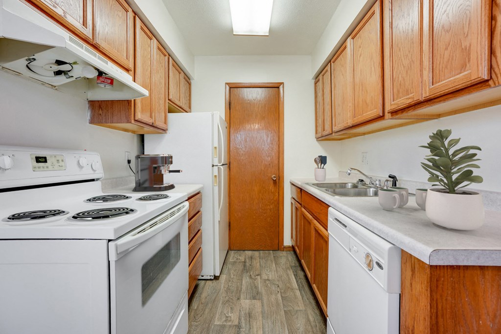 a kitchen with white appliances and wooden cabinets