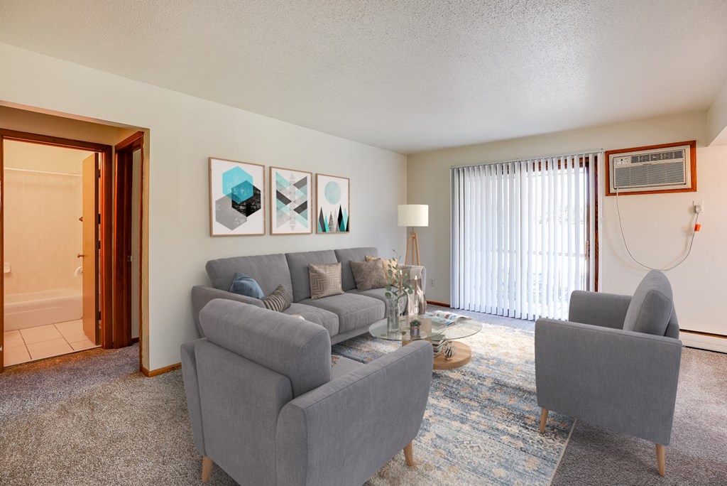 a living room with a couch and two chairs and a sliding glass door