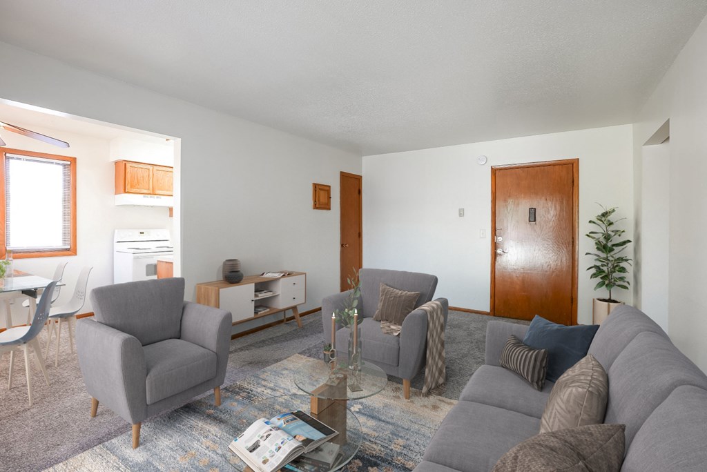 a living room with a couch and two chairs and a table