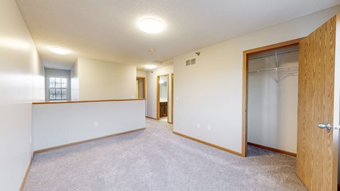 A spacious room with a carpeted floor and a sliding glass door.