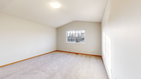 A room with a window and carpeted floor.
