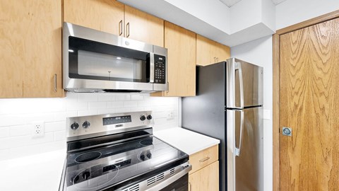 A kitchen with a stove, oven, microwave, and refrigerator.