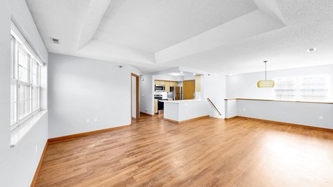 A spacious room with wooden floors and white walls.