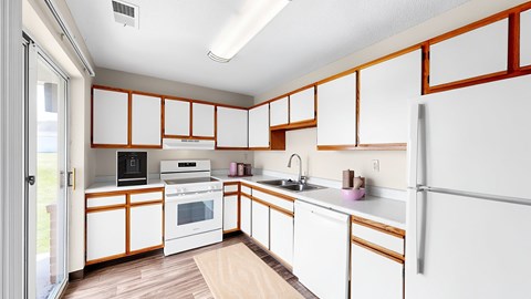 A kitchen with white cabinets and a white refrigerator.