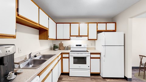 A kitchen with white appliances and wooden cabinets.