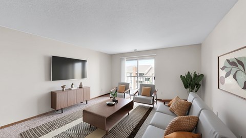 A living room with a grey couch, a brown coffee table, and a flat screen TV mounted on the wall.