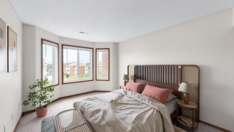 A bedroom with a large bed and a potted plant.
