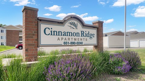 A sign for Cinnamon Ridge Apartments with a phone number on it.