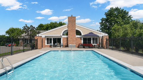 A house with a pool in front of it.