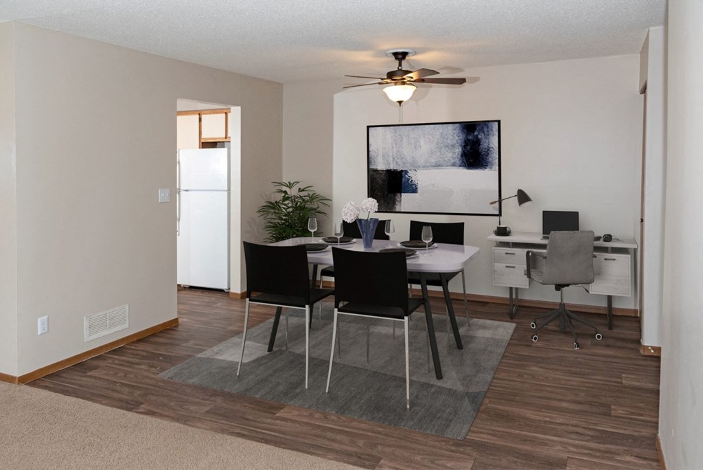 a dining area with a table and chairs and a ceiling fan