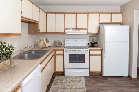 a kitchen with a white refrigerator freezer next to a white stove top oven