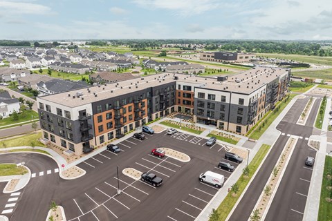 A large parking lot in front of a multi-story building.
