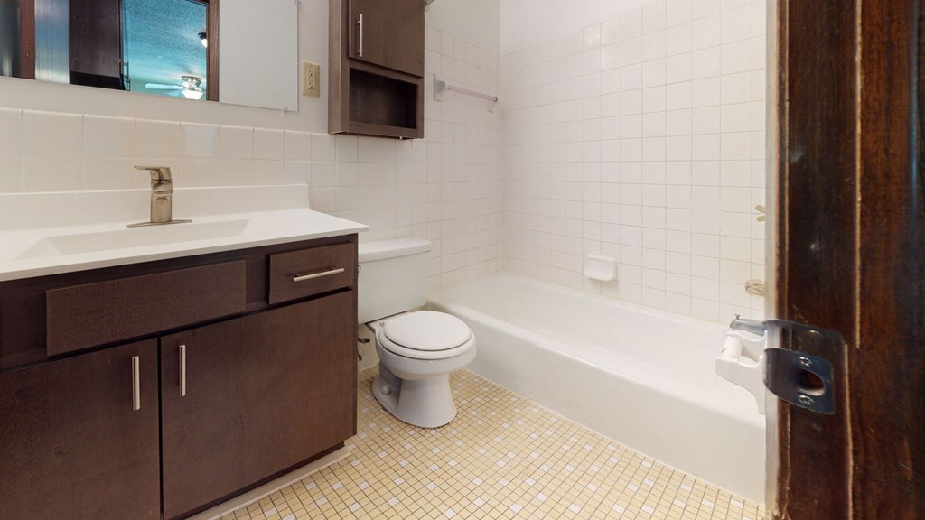 a bathroom with a toilet and a sink and a bath tub