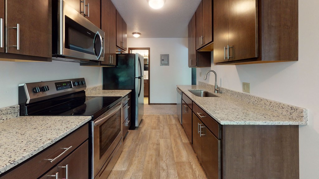 a kitchen with wood cabinets and granite counter tops and black appliances