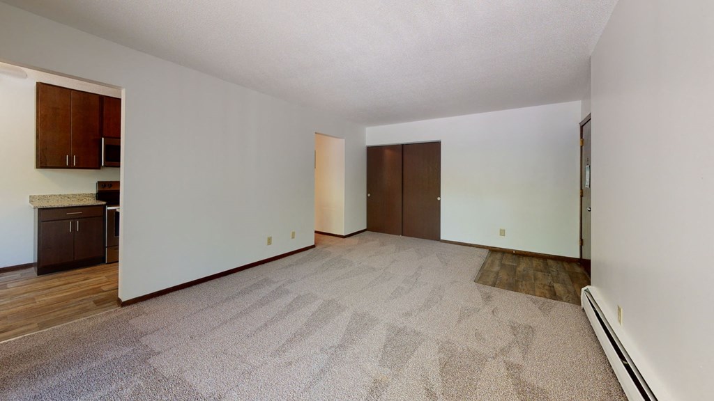 an empty living room with wood flooring and white walls