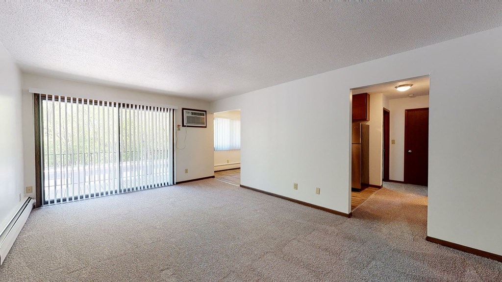 an empty living room with a large window and a door