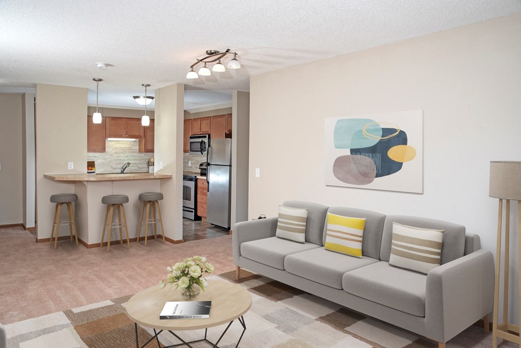 a living room and kitchen with a couch and a table