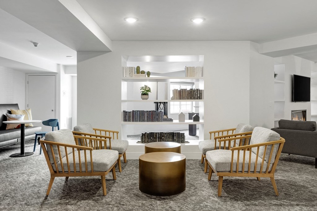 a living room with white walls and wooden chairs