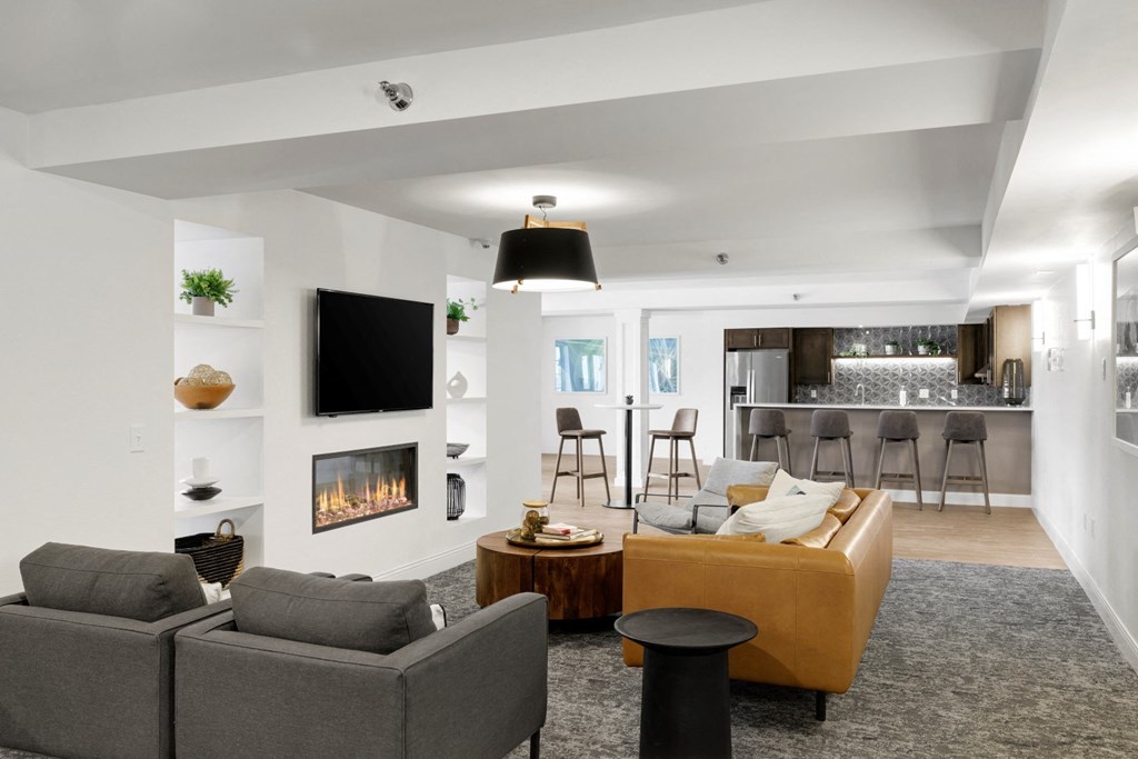 a living room with a fireplace and a kitchen in the background