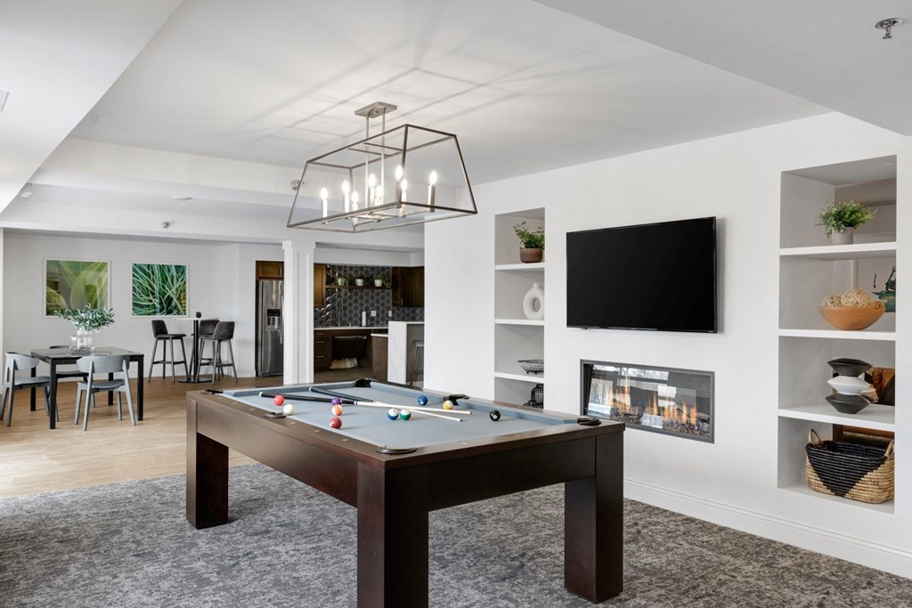 a living room with a pool table and a television
