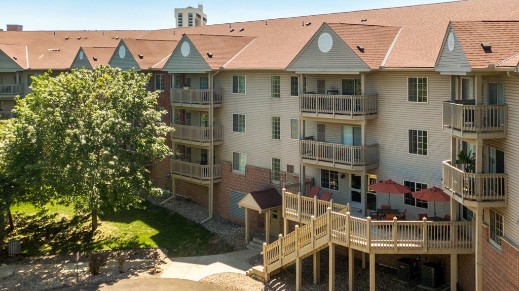 an aerial view of an apartment building with balconies and a tree