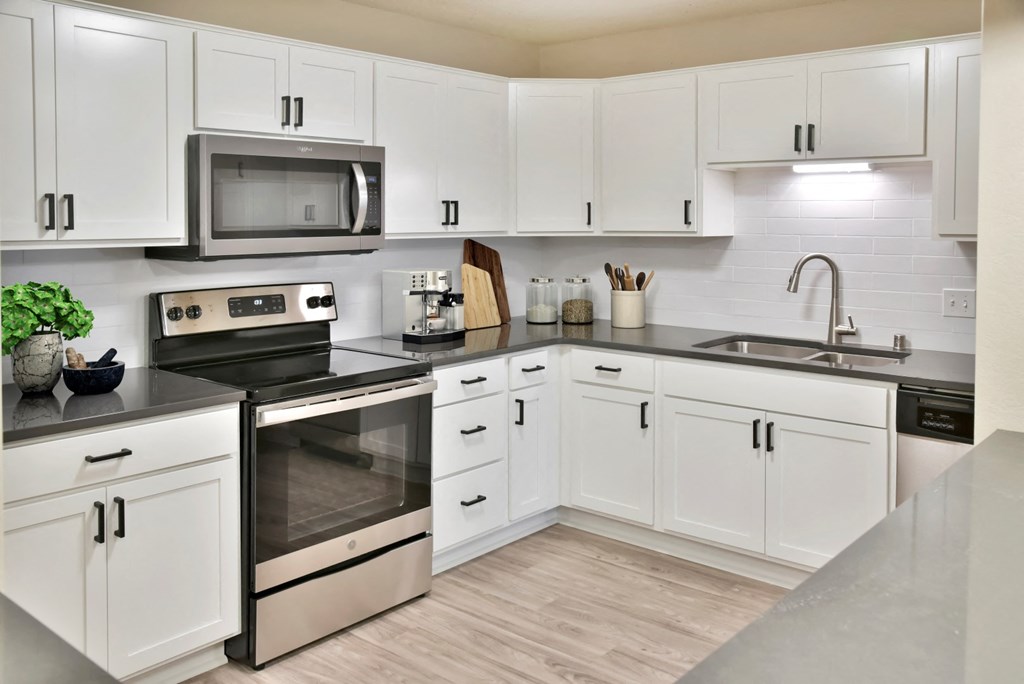 a kitchen with white cabinets and stainless steel appliances
