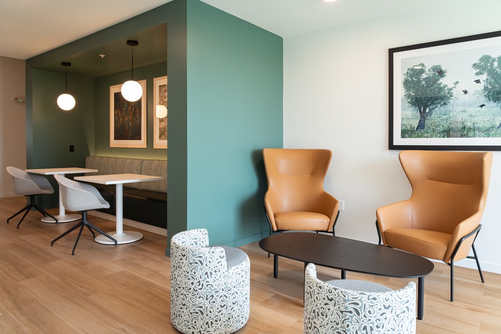 A room with a table, chairs and a painting on the wall.