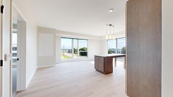 A room with a wooden floor and a table with a cabinet.