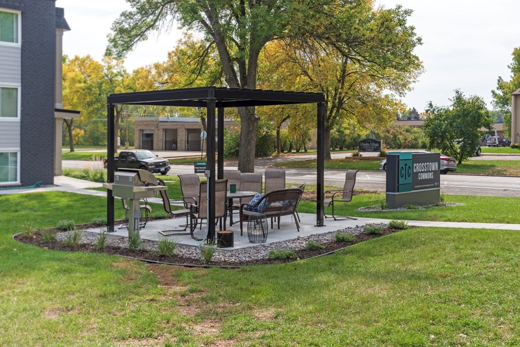 a patio with a table and chairs in a park