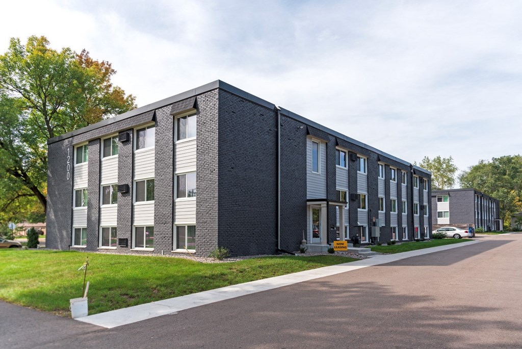 the exterior of a multifamily building with a street in front of it