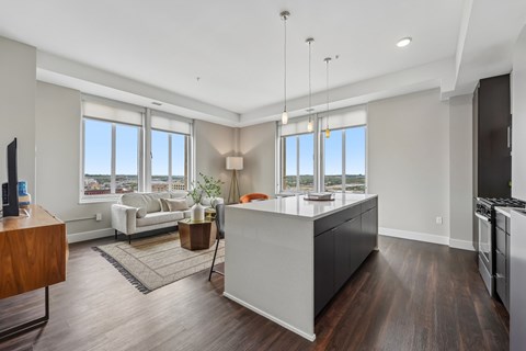 A modern kitchen with a wooden floor and white walls.