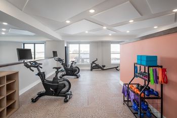 A room with exercise equipment and a rack of kettlebells.at The Edison at Maple Grove, Minnesota