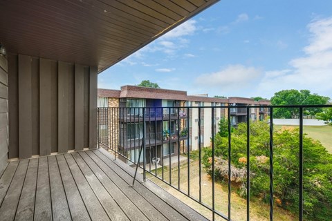 a balcony with a wooden floor and a metal railing