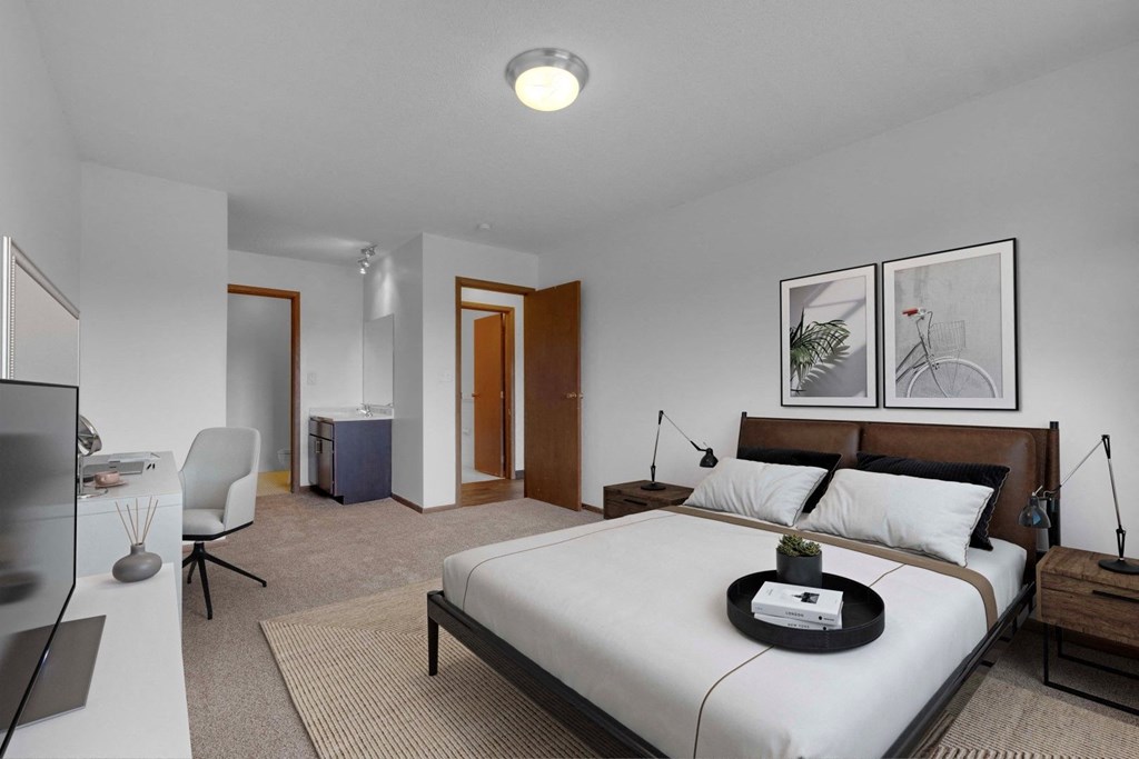 a bedroom with a bed and a desk in a room