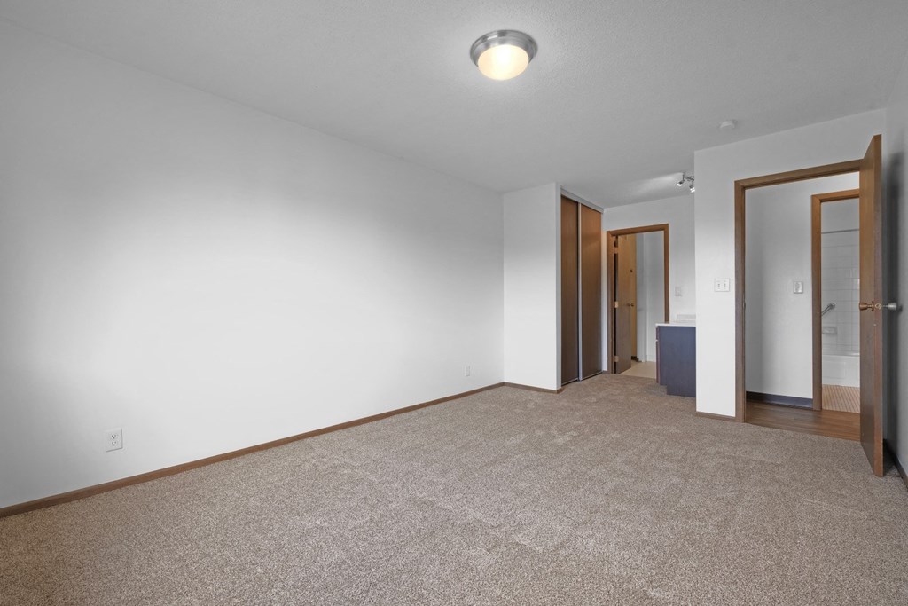 a bedroom with white walls and a carpeted floor