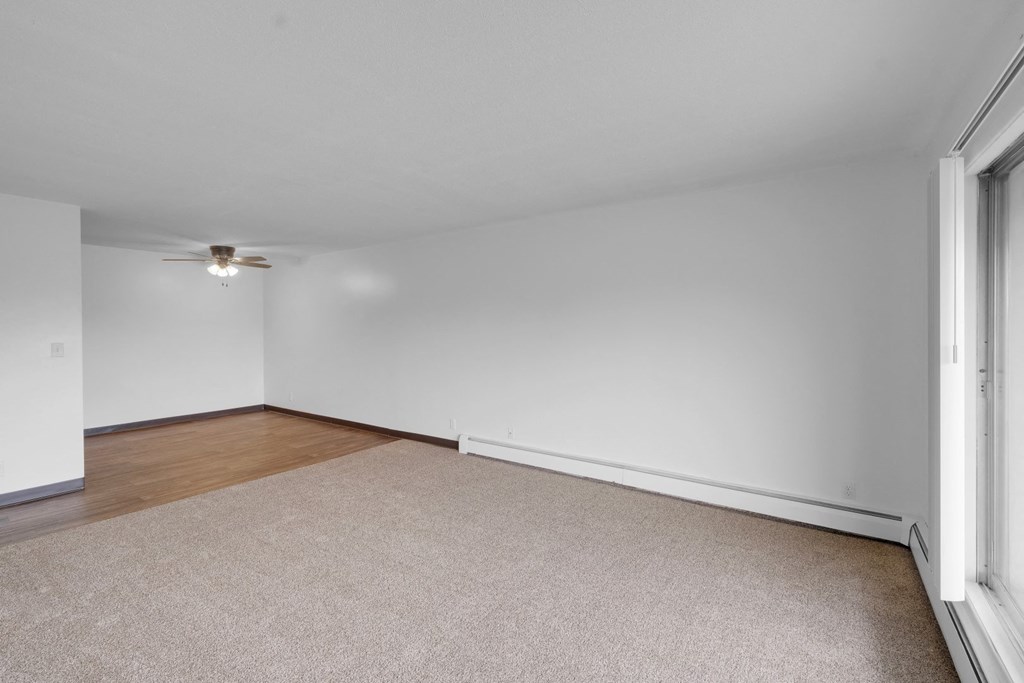 a bedroom with white walls and a ceiling fan