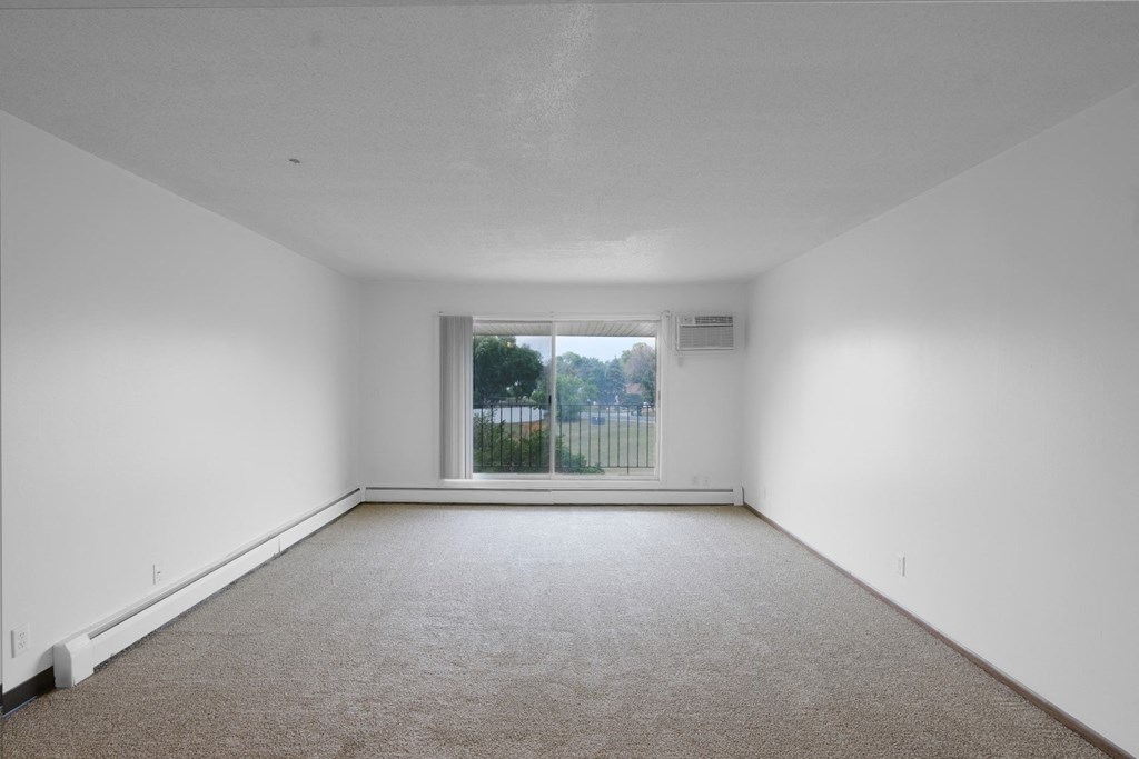 a bedroom with a large window and white walls