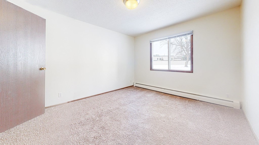 a bedroom with white walls and carpet