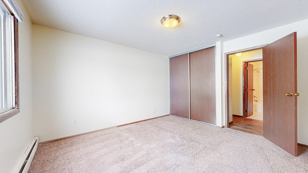 a bedroom with two doors and a carpeted floor