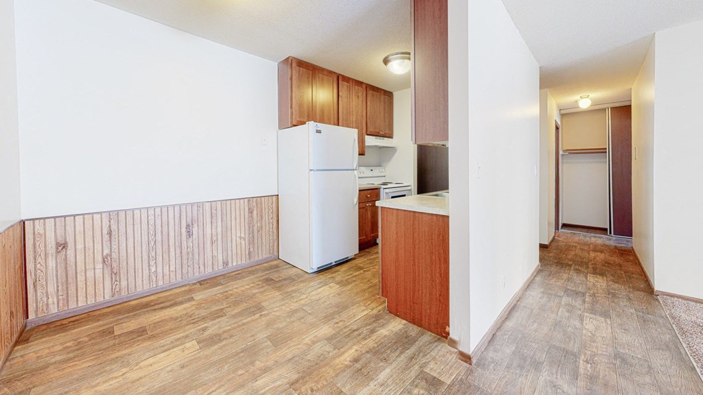 a kitchen with a white refrigerator freezer next to a white stove top oven