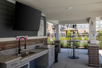 A kitchen with a sink and a bar stool.at The Edison at Spirit, Lakeville, MN 55044