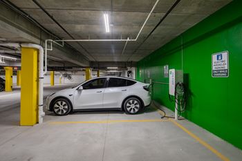 A white car is parked in an underground parking garage.at The Edison at Spirit, Minnesota